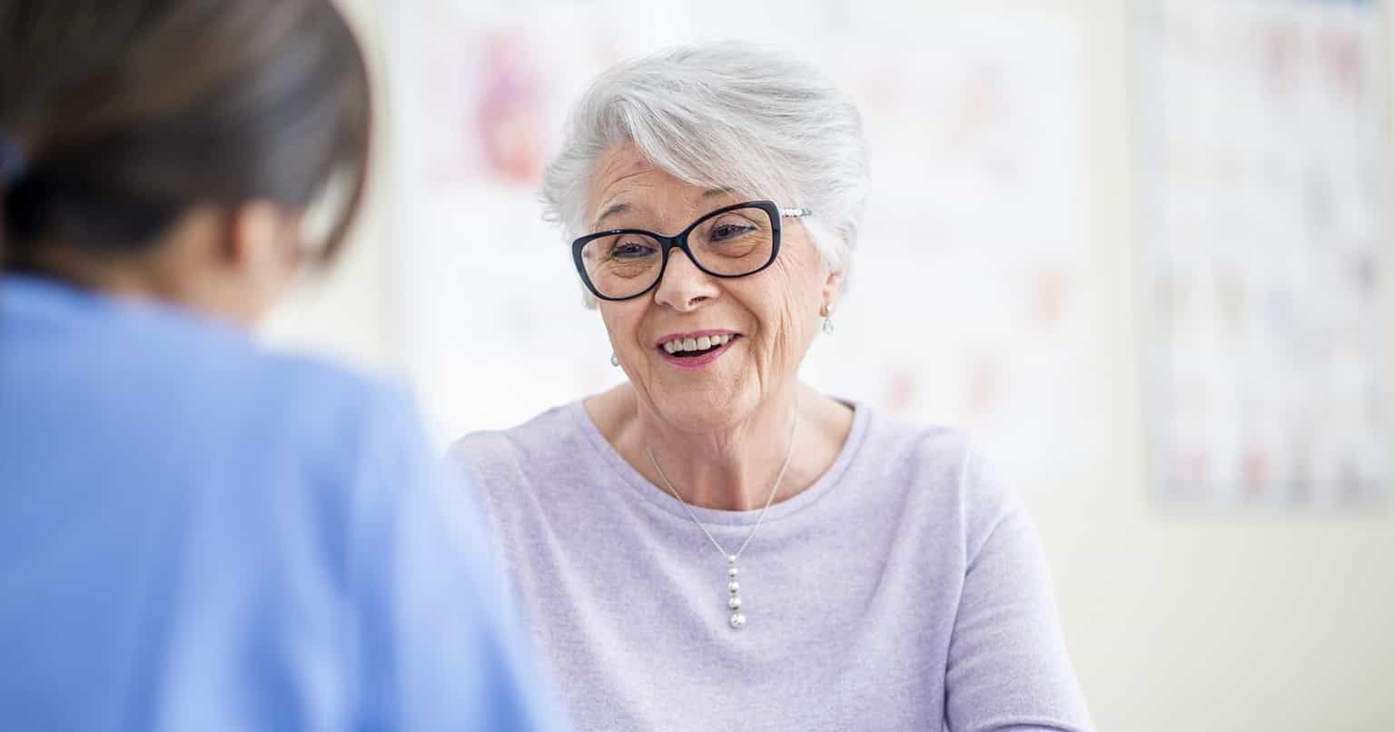senior woman with provider clinic e1695410376452